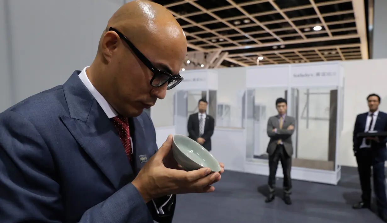 Sebuah mangkuk berusia 1.000 tahun dari Dinasti Song diperlihatkan seorang staf Balai Lelang Sotheby di Hong Kong, Selasa (3/10). Benda itu terjual kepada seorang pembeli anonim setelah melalui adu penawaran selama 20 menit. (AP/Kin Cheung)