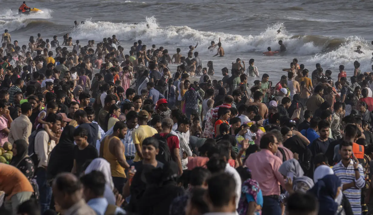 <p>Warga memadati pantai Juhu di Laut Arab pada hari yang panas dan lembab di kota Mumbai, India, 8 Mei 2022. Musim panas yang terik di India menambah risiko baru tahun ini. Suhu di India melebihi 40 derajat Celcius di banyak daerah. (AP Photo/Rafiq Maqbool)</p>