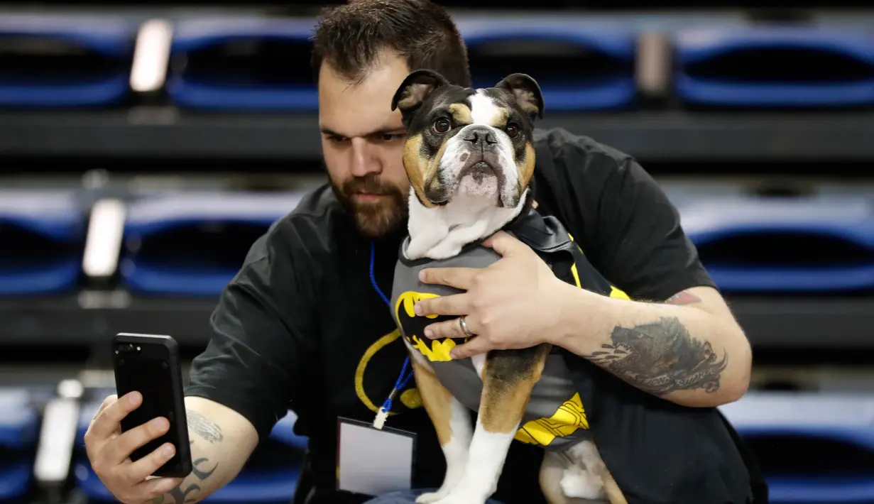 Erin Carlo berfoto bersama bulldognya yang bernama Charlie saat mengikuti kontes Drake Relays Beautiful Bulldog ke-38 di Des Moines, Iowa (23/4). Dalam kontes ini bulldog mengenakan aneka kostum yang unk. (AP Photo / Charlie Neibergall)