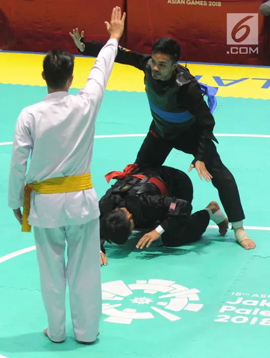 Pesilat Indonesia Abdul Malik (biru) bertanding melawan Muhammad Faizul M Nasir (merah) asal Malaysia di final Kelas B Putra Asian Games 2018 di Jakarta, Senin (27/8). Abdul menang dan mendapatkan medali emas. (Merdeka.com/Arie Basuki)