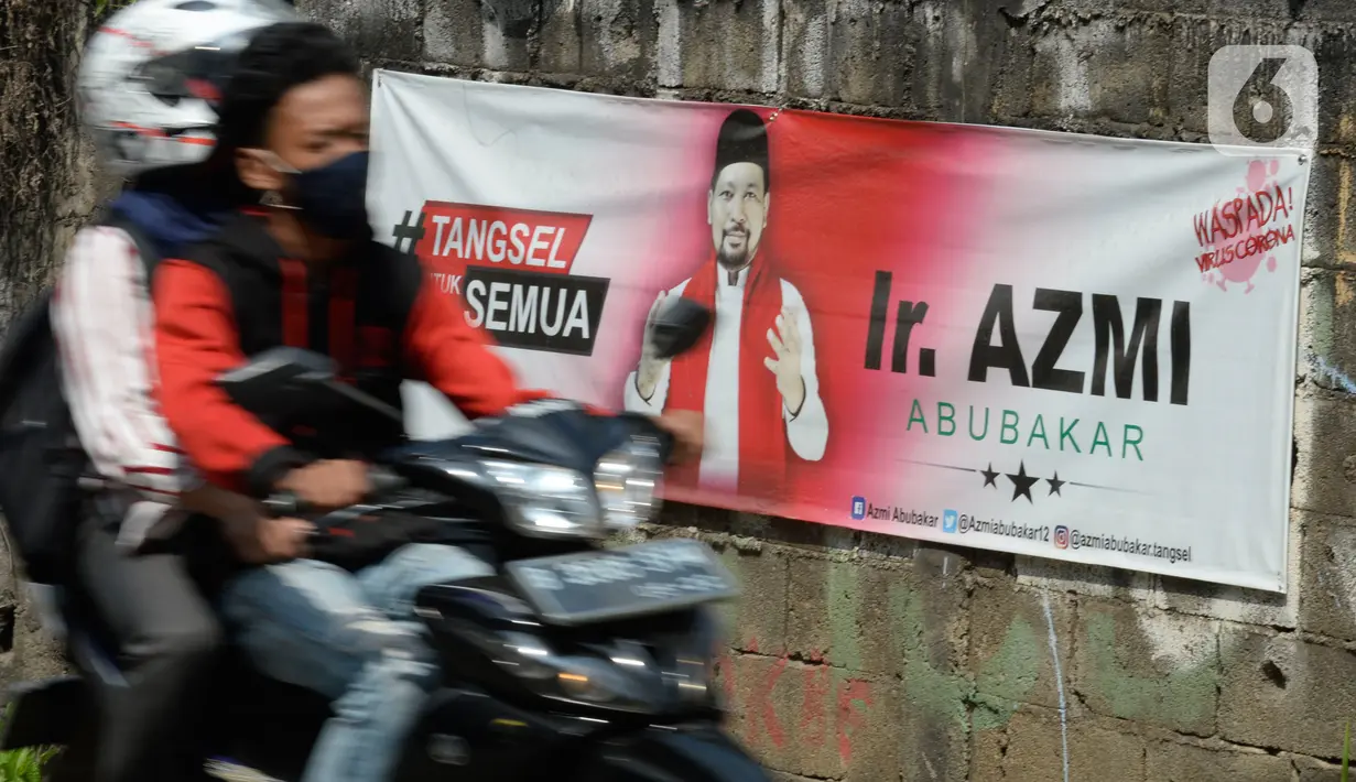 Pengendara motor melintas di dekat spanduk Bakal Calon Wali Kota Tangerang Selatan periode 2021–2026 yang menghiasi jalan protokol di Tangerang Selatan, Banten, Senin (27/07/2020). (merdeka.com/Dwi Narwoko)