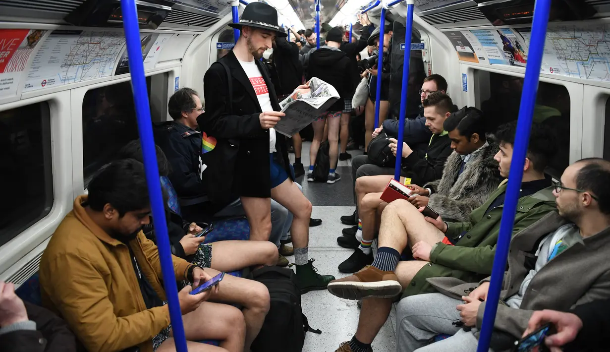 Orang-orang mengambil bagian dalam 'No Trousers On The Tube Day' atau No Pants Subway Ride di London Underground,  pusat Kota London, Minggu (12/1/2020). Untuk tahun ini, acara naik kereta tanpa celana itu dilangsungkan serentak di sejumlah kota dunia pada 12 Januari. (DANIEL LEAL-OLIVAS/AFP)