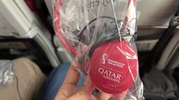 Salah satu fasilitas yang diberikan dalam perjalanan yakni headphone memiliki tulisan Piala Dunia 2022dibagian telinga. (Bola.com/Ade Yusuf Satria)