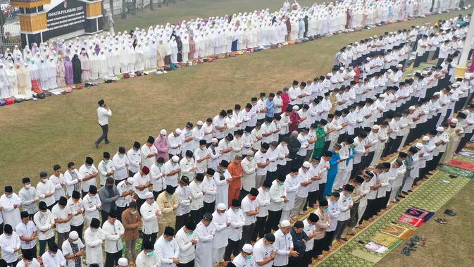 Foto dari udara, umat muslim melaksanakan salat minta hujan (Istisqa) saat kabut asap menyelimuti kota Pekanbaru, di Riau, Jumat (13/9/2019). Kegiatan ini untuk meminta turunnya hujan guna mengurangi dampak kabut asap kebakaran hutan dan lahan di sejumlah wilayah di Provinsi Riau. (ADEK BERRY/AFP)