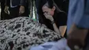 Kekasih almarhum Andika Putra Sahadewa, Nicky Santoso menangis di dekat makam di TPU Sunan Giri, Rawamangun, Jakarta, Selasa (10/9). Bassist grup band Kerispatih, Andika Putra Sahadewa, meninggal dunia di usia 36 tahun. (Liputan6.com/Faizal Fanani)