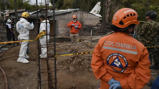 Tim penyelamat berada di lokasi jatuhnya sebuah pesawat kecil di tengah-tengah rumah penduduk di Popayan, Kolombia, Minggu (15/9/2019). Pemadam kebakaran mengatakan tiga orang luka parah, salah satunya adalah seorang anak yang merupakan warga setempat. (Luis ROBAYO / AFP)