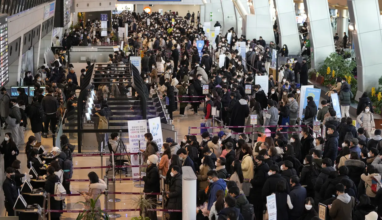 Penumpang yang mengenakan masker antre untuk naik pesawat menjelang liburan Tahun Baru Imlek, di terminal penerbangan domestik bandara Gimpo di Seoul, Korea Selatan, Sabtu (29/1/2022). Libur Imlek di Korsel dimulai mulai 30 Januari hingga 2 Februari mendatang. (AP Photo/Ahn Young-joon)
