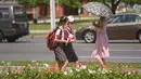 Siswa berjalan di sepanjang jalan saat suhu tinggi mencapai 34 derajat celsius di Pyongyang, Korea Utara, Rabu (21/7/2021). Musim Panas dimulai pada bulan Juni hingga Agustus, dan puncak musim panas adalah bulan Agustus. (KIM Won Jin / AFP)