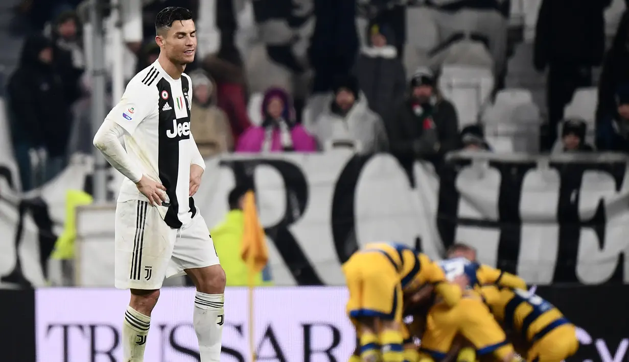 Ekspresi penyerang Juventus, Cristiano Ronaldo (kiri) saat pemain Parma mencetak gol ke gawang Juventus dalam lanjutan Serie A Italia di Allianz Stadium, Turin, Sabtu (2/2). Juventus ditahan imbang Parma dengan skor 3-3. (Marco BERTORELLO/AFP)