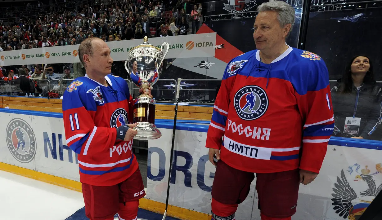 Presiden Rusia Vladimir Putin, menerima piala dari mantan pemain Soviet Alexander Yakushev usai bermain hoki es dalam acara gala game Ice Hockey League di Sochi, Rusia, 10 Mei 2016. (Reuters/ Mikhail Klimentyev/Sputnik/Kremlin)