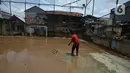 Warga membersihkan lumpur sisa banjir di Kelurahan Rawa Jati, Jakarta, Selasa (9/2/2021). Endapan lumpur yang mengendap akibat luapan Kali Ciliwung. (merdeka.com/Imam Buhori)