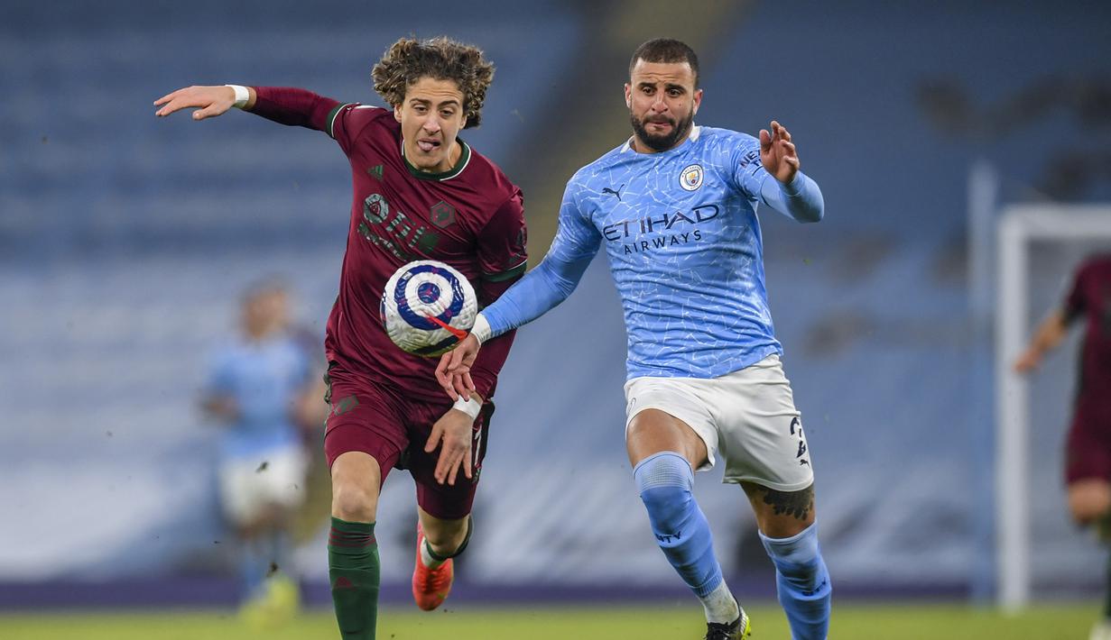 Striker Wolverhampton Wanderers, Fabio Silva (kiri) berebut bola dengan bek Manchester City, Kyle walker dalam laga lanjutan Liga Inggris 2020/21 pekan ke-27 di Etihad Stadium, Selasa (2/3/2021). Wolverhampton kalah 1-4 dari Manchester City. (AP/Paul Ellis/Pool)