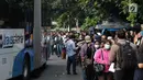 Masyarakat mengantre untuk menaiki bus Transjakarta di depan Cibubur Junction, Jakarta, Senin (16/4). Imbas penerapan penerapan ganjil genap di ruas Gerbang Tol Cibubur 2 sebagaian masyarakat memilih menggunakan Transjakarta. (Liputan6.com/Faizal Fanani)