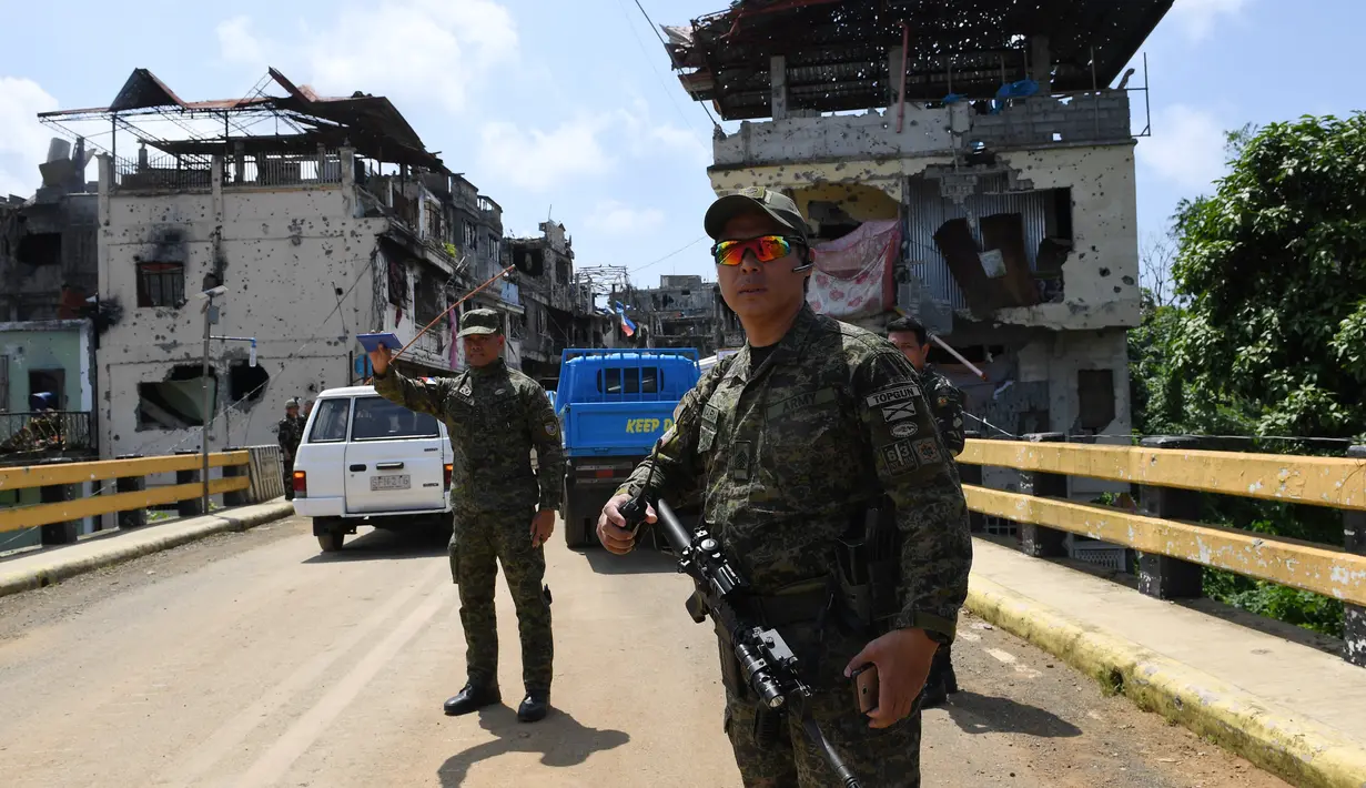Militer Filipina berjaga di Kota Marawi, Mindanao, Filipina, Minggu (1/4). Pemulangan warga Marawi akan dilakukan secara bertahap hingga pembangunan kembali kota itu dilakukan. (TED ALJIBE/AFP)