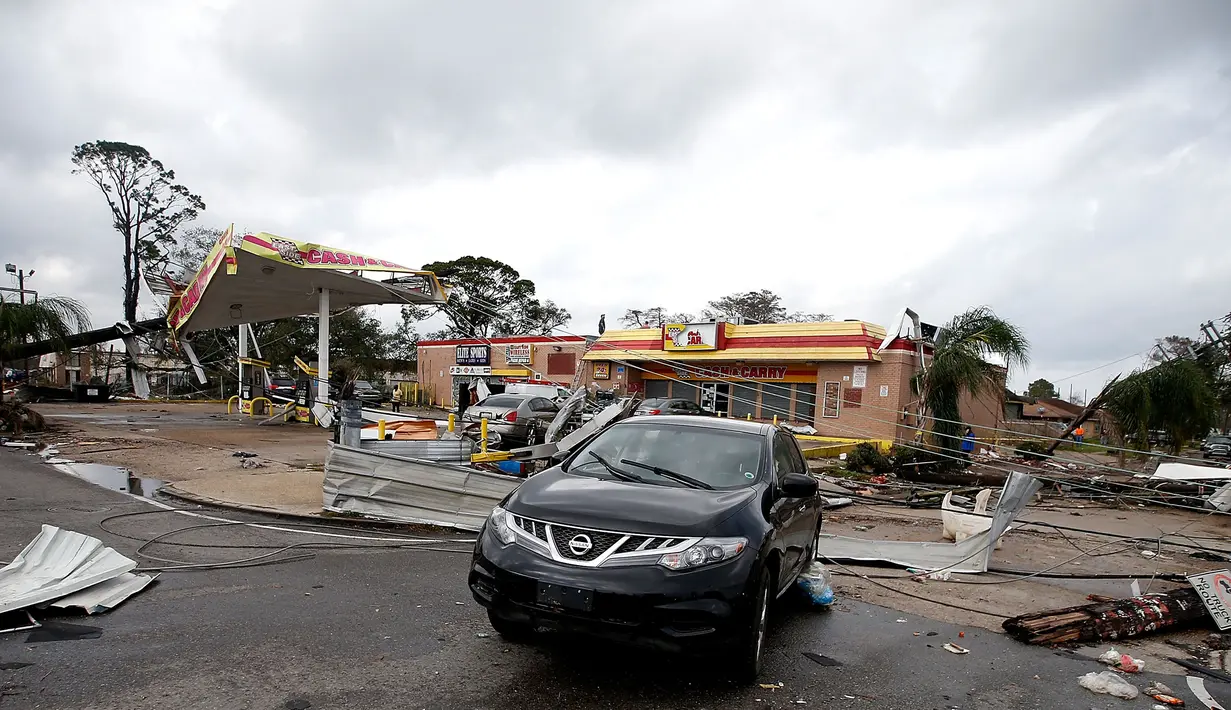 Sebuah pom bensin rusak berat akibat hantaman Tornado di New Orleans, AS (7/2). Selain merusak banyak bangunan dan menumbangkan tiang listrik, tornado juga menerbangkan atap rumah serta menggulingkan truk makanan. (Sean Gardner/Getty Images/AFP)