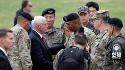 Wakil Presiden AS, Mike Pence disambut tentara Amerika dan Korea Selatan setibanya di Camp Bonifas, pos komando PBB yang dipimpin AS, dekat bagian selatan Zona Demiliterisasi di perbatasan Korsel dan Korut, Senin (17/4). (AP Photo/Lee Jin-man)