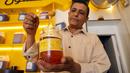 Seorang pedagang mengambil madu dari botol di tokonya di Kota Taez, Yaman, 28 Juni 2022. PBB mengatakan madu memainkan "peran penting" bagi perekonomian Yaman, dengan 100.000 rumah tangga bergantung padanya untuk mata pencaharian mereka. (AHMAD AL-BASHA/AFP)