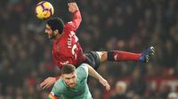 Gelandang Manchester United, Marouane Fellaini, duel udara dengan bek Arsenal, Shkodran Mustafi pada laga Premier League di Stadion Old Trafford, Manchester, Rabu (5/12). Kedua klub bermain imbang 2-2. (AFP/Oli Scarff)