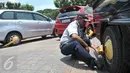 Petugas menggembok roda kendaraan hasil razia parkir liar di kawasan Jakarta, Senin (13/3). Denda parkir liar di DKI Jakarta selama periode Januari hingga Februari 2017 mencapai Rp1,82 miliar. (Liputan6.com/Yoppy Renato)