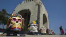 Warga mengambil gambar Fridacraneos, tengkorak raksasa yang dilukis untuk menghormati mendiang seniman Meksiko Frida Kahlo, sebagai bagian dari perayaan Hari Kematian di Monumen Revolusi, Mexico City, Meksiko, 29 Oktober 2021. (Claudio CRUZ/AFP)