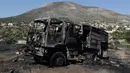 Sebuah mobil pemadam kebakaran hangus dalam kebakaran lahan yang melanda dekat Kalyvia, Yunani, Kamis (3/8). Puluhan petugas dan mobil pemadam kebakaran dikerahkan dalam operasi pemadaman kebakaran besar tersebut. (AP/Thanassis Stavrakis)