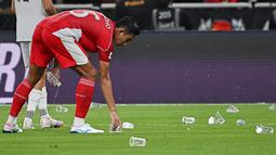 Hal tersebut sempat menunda pertandingan karena gelas dan botol plastik tersebut masuk ke dalam lapangan pertandingan. (AP Photo/Ali Issa)