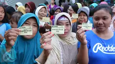 Warga menunjukkan kupon yang akan ditukarkan dengan paket sembako murah dari Indosiar di Joglo, Jakarta, Senin (13/6). Paket berisikan 5 kg beras, 2 liter minyak goreng, 1 kg gula pasir dan 1 kg tepung terigu dijual Rp 30 ribu‎ (Liputan6.com/Angga Yuniar)