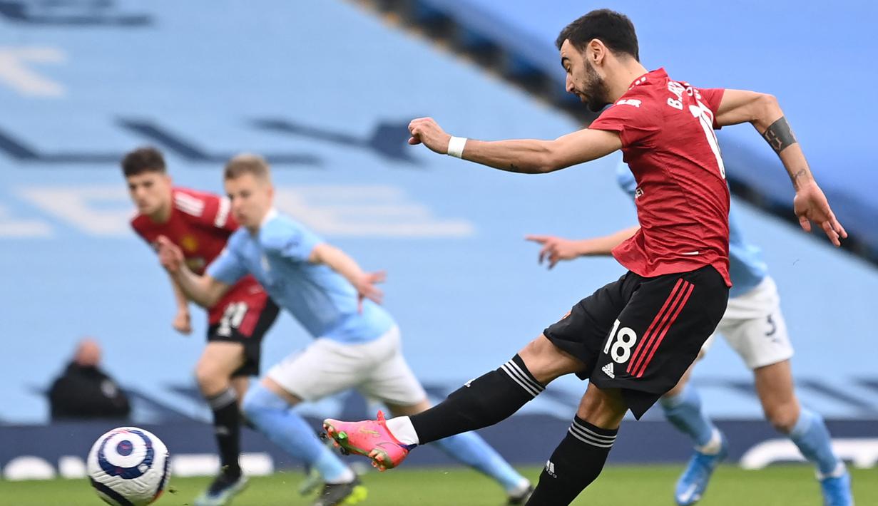 Gelandang Manchester United, Bruno Fernandes melakukan eksekusi penalti yang berbuah gol pertama timnya ke gawang Manchester City dalam laga lanjutan Liga Inggris 2020/21 di Etihad Stadium, Minggu (7/3/2021). MU menang 2-0 atas Mancity. (AFP/Laurence Griffiths/Pool)
