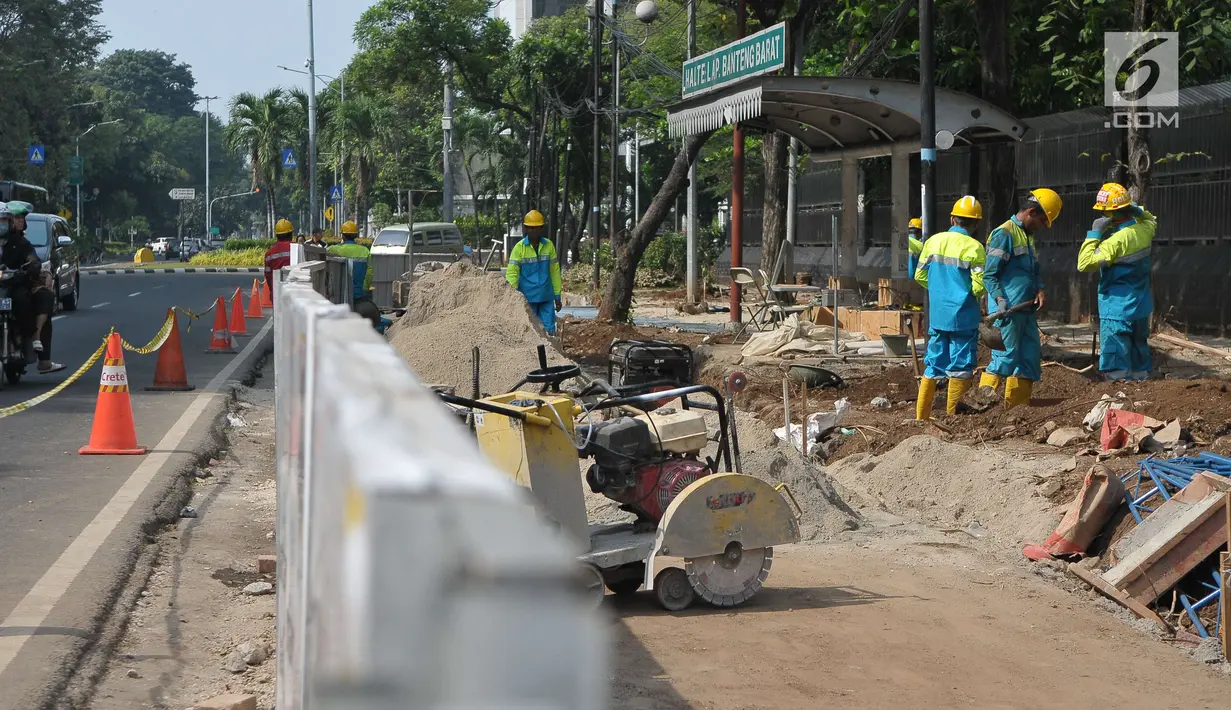 Pekerja menyelesaikan pembangunan pedestrian di Jalan Lapangan Banteng, Jakarta, Minggu (16/7). Pemprov DKI Jakarta menargetkan dapat membangun pedestrian sepanjang 45 kilometer per tahun. (Liputan6.com/Helmi Afandi)