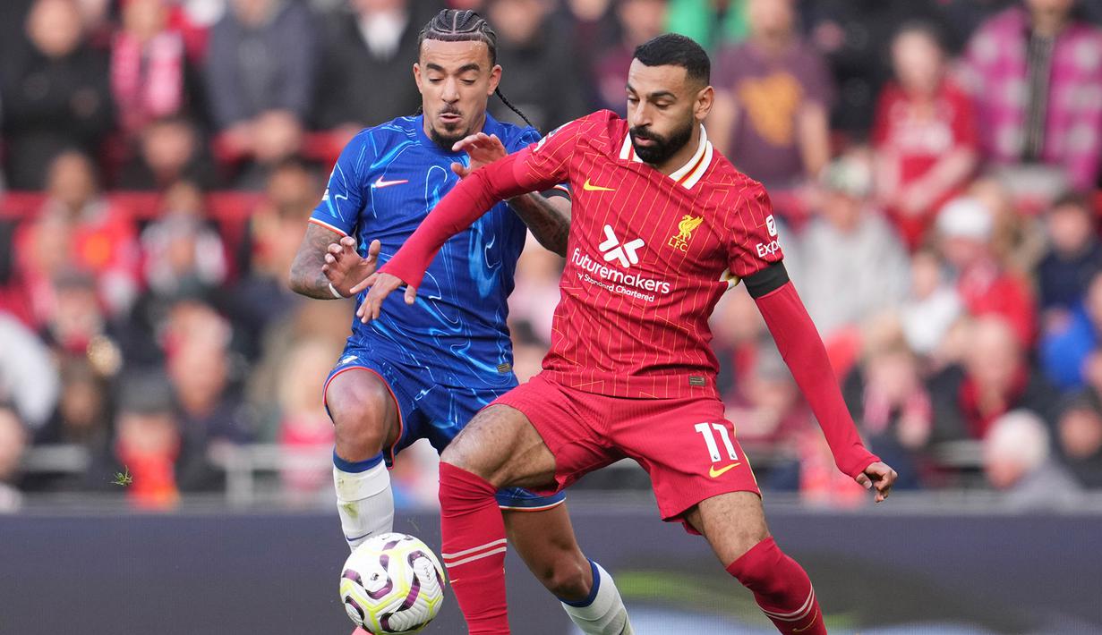 Mohamed Salah (kanan) mencoba mempertahankan bola dari rebutan Malo Gusto saat Liverpool bertanding melawan Chelsea di pekan ke delapan Premier League 2024/2025 di Anfield, Minggu (20/10/2024) malam WIB. (Jon Super/AP)