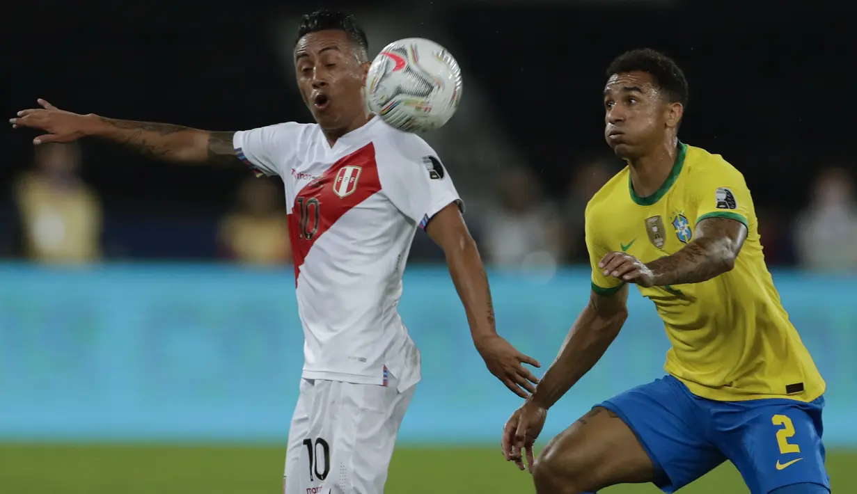 Gelandang timnas Peru, Christian Cueva dan bek Brasil Danilo berebut bola pada laga Copa America 2021 di stadion Nilton Santos, Jumat (18/6/2021). Brasil menang 4-0 atas Peru lewat gol Alex Sandro, Neymar, Everton Ribeiro dan Richarlison. (AP Photo/Silvia Izquierdo)
