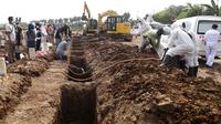 Pekerja menyiapkan deretan kuburan baru yang diperuntukkan bagi mereka yang meninggal karena COVID-19 di TPU Rorotan, Jakarta, Rabu (7/7/2021). Indonesia menghadapi gelombang kedua COVID-19. (AP Photo/Tatan Syuflana)