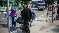 Pemudik membawa barang bawaan setibanya di Terminal Bus Kampung Rambutan, Jakarta Timur, Minggu (9/6/2019). Jumlah penumpang yang memasuki terminal Kampung Rambutan dalam arus balik Lebaran 2019 diperkirakan bakal memuncak pada Minggu (9/6) ini. (Liputan6.com/Faizal Fanani)