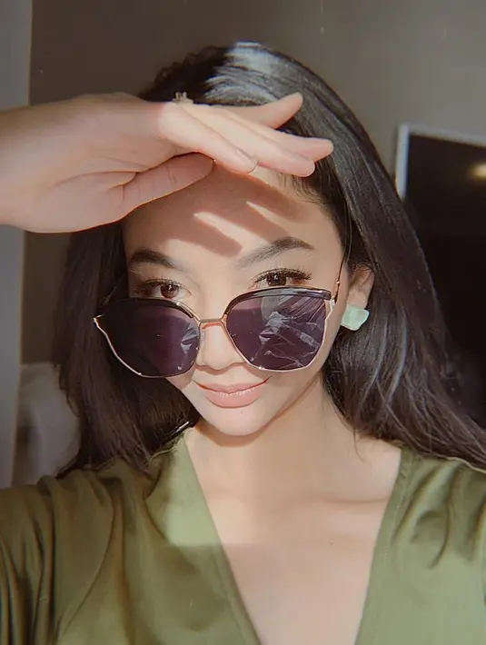 Selain untuk menghindari paparan sinar matahari, kacamata menjadi salah satu fashion item yang tak boleh terlewatkan oleh GLenca Chysara. Mengenakan kacamata hitam dan rambut terurai, wanita 25 tahun ini tampak makin memesona.(Liputan6.com/IG/@glencachysaraofficial)