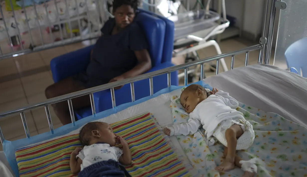 Sepasang bayi kembar beristirahat di tempat tidur Rumah Sakit Anak Saint Damien Port-au-Prince, Haiti, Minggu (24/10/2021). Dilanda krisis, rumah sakit pediatri utama ibu kota hanya memiliki bahan bakar yang tersisa 3 hari untuk menjalankan ventilator dan peralatan medis. (AP/Matias Delacroix)