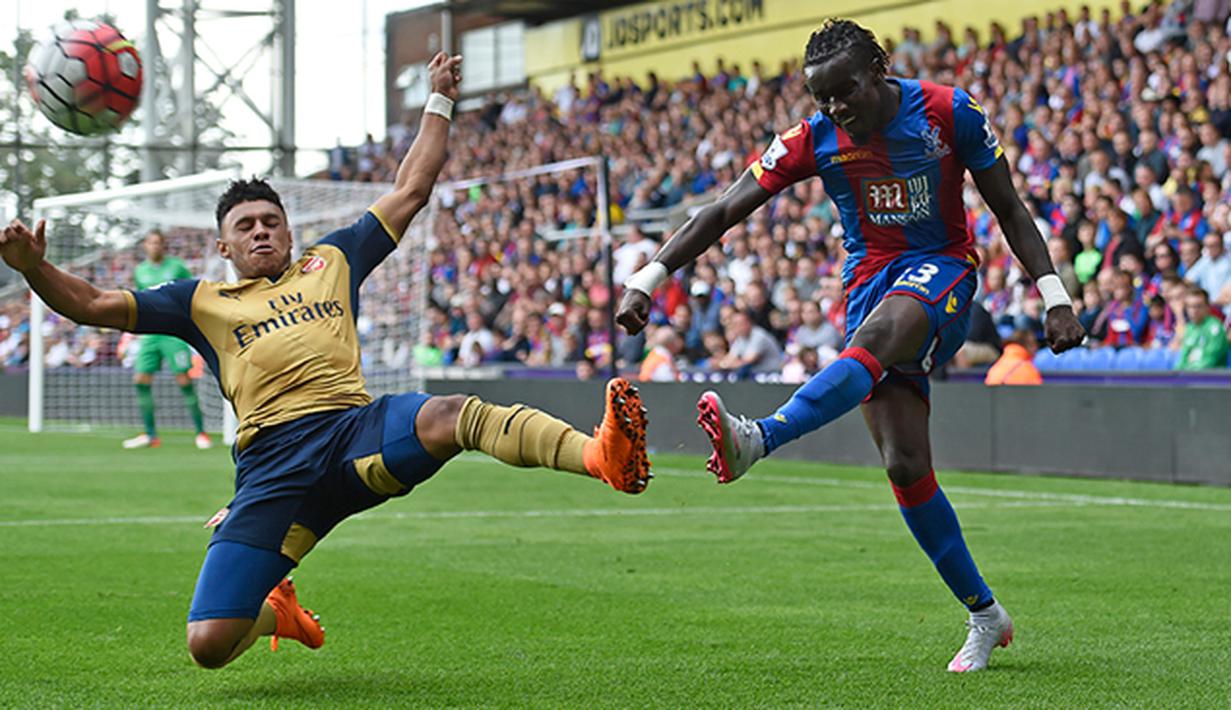 Pemain Crystal Palace, Pape Souare membuang bola dari jangkauan pemain Arsenal, Oxlade Chamberlain pada laga Liga Inggris di Stadion Selhurst Park, Inggris, Minggu (16/8/2015). Arsenal taklukan Palace 2-1. (Reuters/Toby Melville)