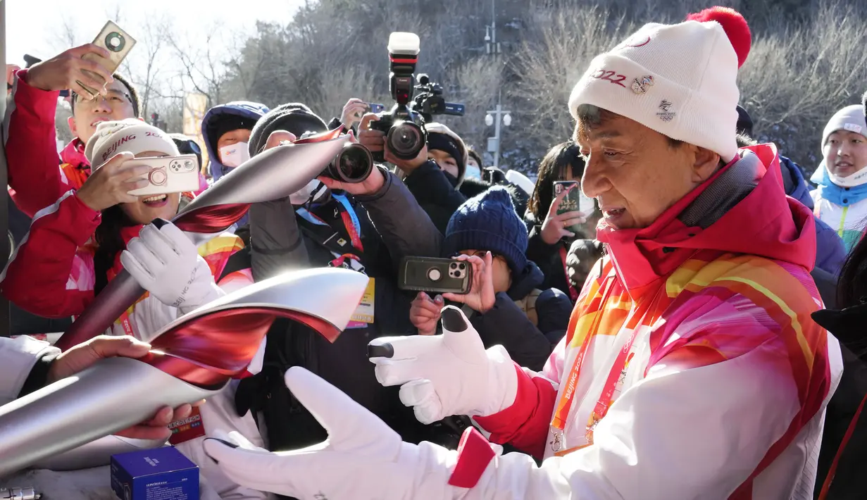 Selebriti Hong Kong Jackie Chan menerima obor Olimpiade Musim Dingin 2022 setelah mengambil bagian dalam estafet obor di Tembok Besar Badaling di pinggiran Beijing, Cina, Kamis, 3 Februari 2022. (AP/Ng Han Guan)