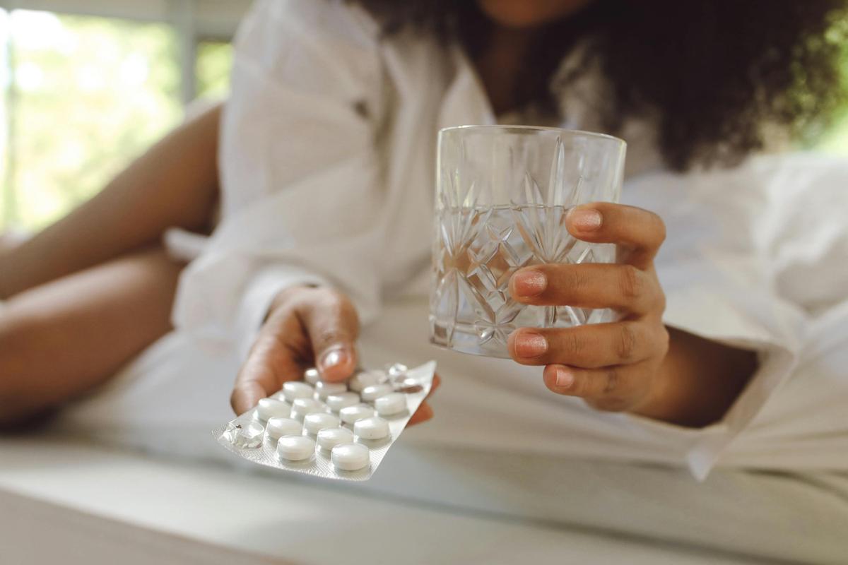 Wanita sedang minum obat