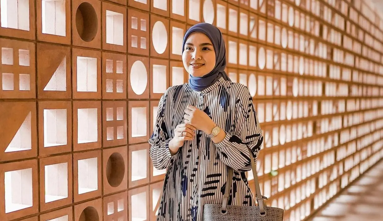 Untuk gaya smart casual, tampilan desainer Ria Miranda yang memadukan blouse bermotif warna navy, dengan hijab polos warna senada, serta ruffle skirt warna putih ini bisa jadi pilihan. (Instagram/riamiranda).