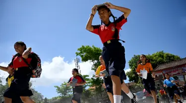 Sejumlah pelajar berlari saat mengambil bagian dalam latihan simulasi gempa bumi dan tsunami di Jimbaran, Bali (5/11/2019). Latihan dilakukan untuk memberikan pengajaran kepada siswa agar mengantisipasi bahaya bencana gempa bumi dan tsunami yang bisa datang sewaktu-waktu. (AFP Photo/Sonny Tumbelaka)