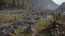Seorang pria Kashmir bersama putranya berjalan pulang membawa pasir yang dikumpulkan dari sungai di atas punggung kuda di Naranag, tujuan wisata di utara Srinagar, Kashmir yang dikuasai India (31/10/2021). (AP Photo/Dar Yasin)