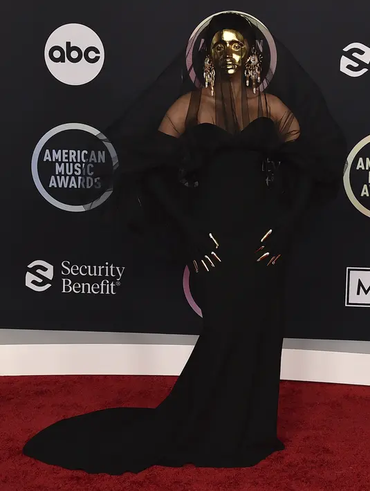 Cardi B berpose saat tiba di American Music Awards di Microsoft Theater di Los Angeles (22/11/20210). Di karpet merah, pelantun Bodak Yellow itu tampil dengan topeng emas. (AP Photo/Jordan Strauss)