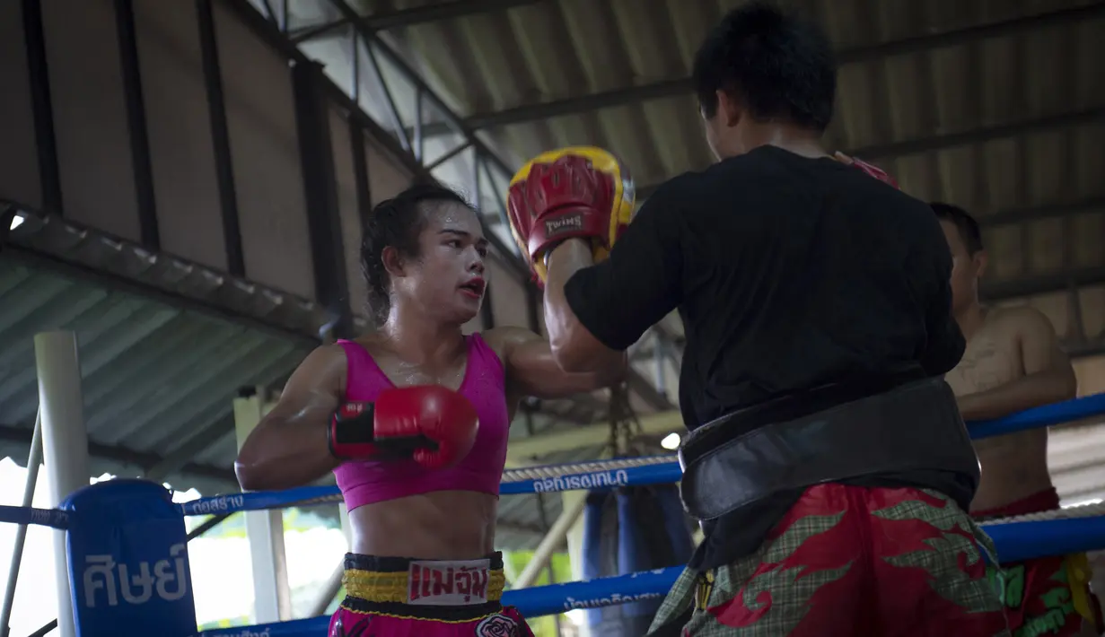 Ekspresi Nong Rose saat melakukan latihan Muay Thai di provinsi Chachoengsao, Thailand (15/12). Bersama saudara laki-lakinya, petinju Muay Thai transgender ini melakukan sesi latihan. (AFP Photo)