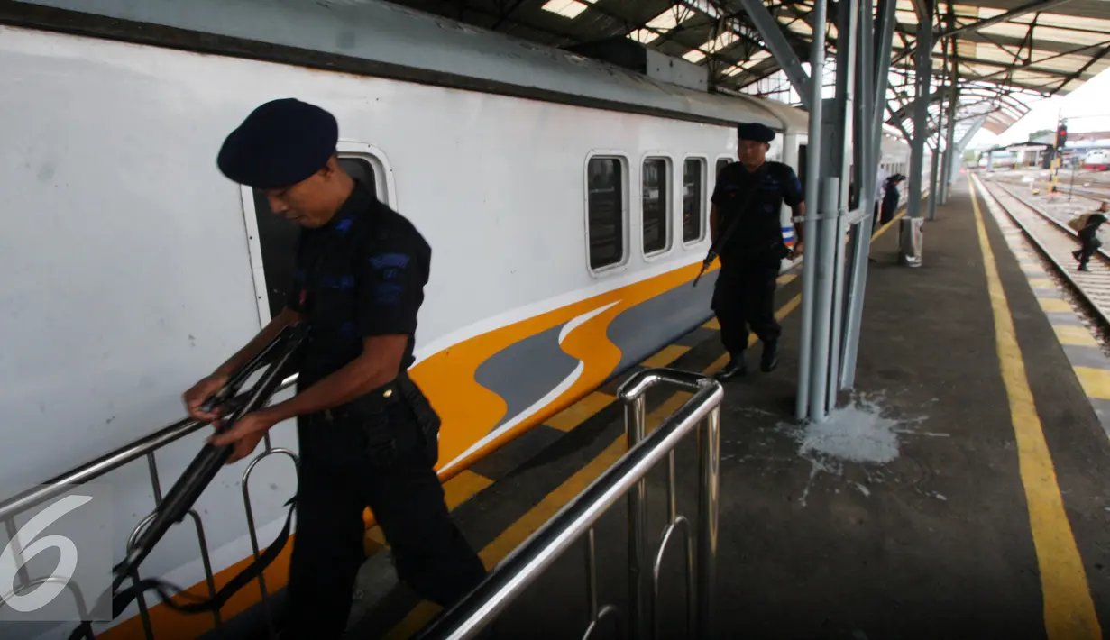 Dua personil brimob mengawal rangkaian gerbong  Kerata Api di Stasiun Tugu, Yogyakarta, Selasa (28/6). Perbaikan di lakukan untuk memperlancar arus mudik dengan menggunakan transportasi layanan kereta api. (Liputan6.com/Boy Harjanto)