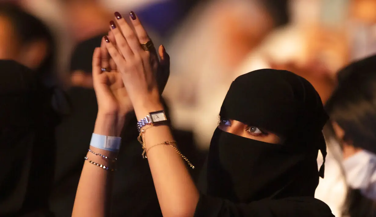 Seorang wanita yang telah divaksinasi virus corona bertepuk tangan saat menonton penyanyi Saudi Mohammed Abdu di Super Dome di Jeddah, Arab Saudi (8/7/2021). Konser ini diselenggarakan Otoritas Hiburan Umum Saudi. (AP Photo/Amr Nabil)