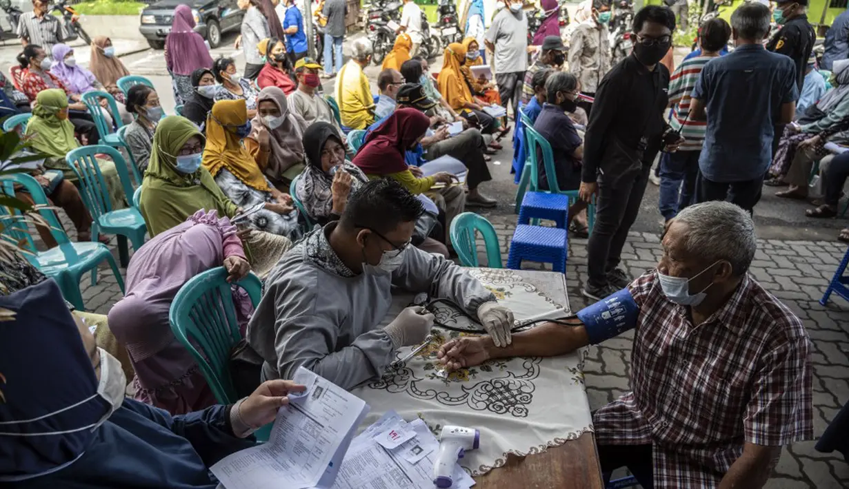 Warga menunggu giliran untuk menerima dosis vaksin booster COVID-19 Pfizer di Surabaya, Jawa Timur, Kamis (13/1/2022). (JUNI KRISWANTO/AFP)