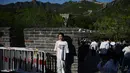 Seorang gadis berpose sat mengunjungi Tembok Besar China di Badaling, utara Beijing, hari pertama dari 5 hari libur nasional Hari Buruh atau May Day, Rabu (1/5/2024). (GREG BAKER / AFP)