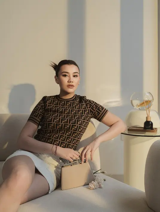 Penampilan luar biasa menawan dari Aaliyah Massaid di photoshoot ini. Ia mengenakan atasan bermotif logo brand, lengan pendek, dipadunya dengan mini skirt berwarna putih dan menenteng mini handbag. [Foto: Instagram/aaliyah.massaid]