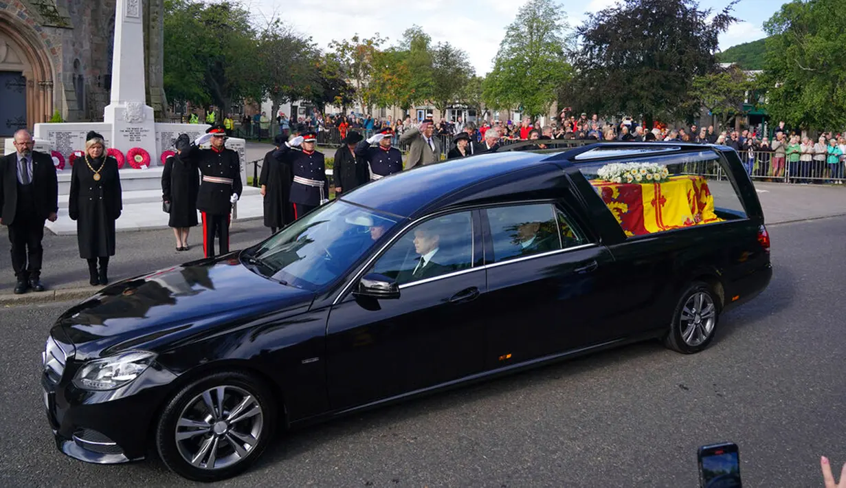 <p>Warga berbaris saat mobil yang membawa peti berisi jenazah Ratu Elizabeth II melintas di Ballater, Skotlandia, Minggu (11/9/2022). Jenazah Ratu Elizabeth II diberangkatkan dari Kastil Balmoral ke Istana Holyroodhouse di Edinburgh sebelum nantinya akan dipindahkan ke London. (Andrew Milligan/PA via AP)</p>
