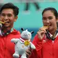 ganda campuran Indonesia Christopher Rungkat (kiri) dan Aldila Sutjiadi menggigit medali emas pada upacara penganugerahan medali seusai menang.